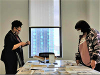 Karen Burton and Saundra Little reviewing documents.